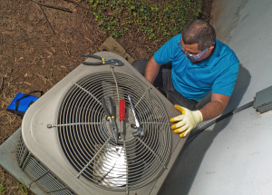 repair man working on central air conditioner